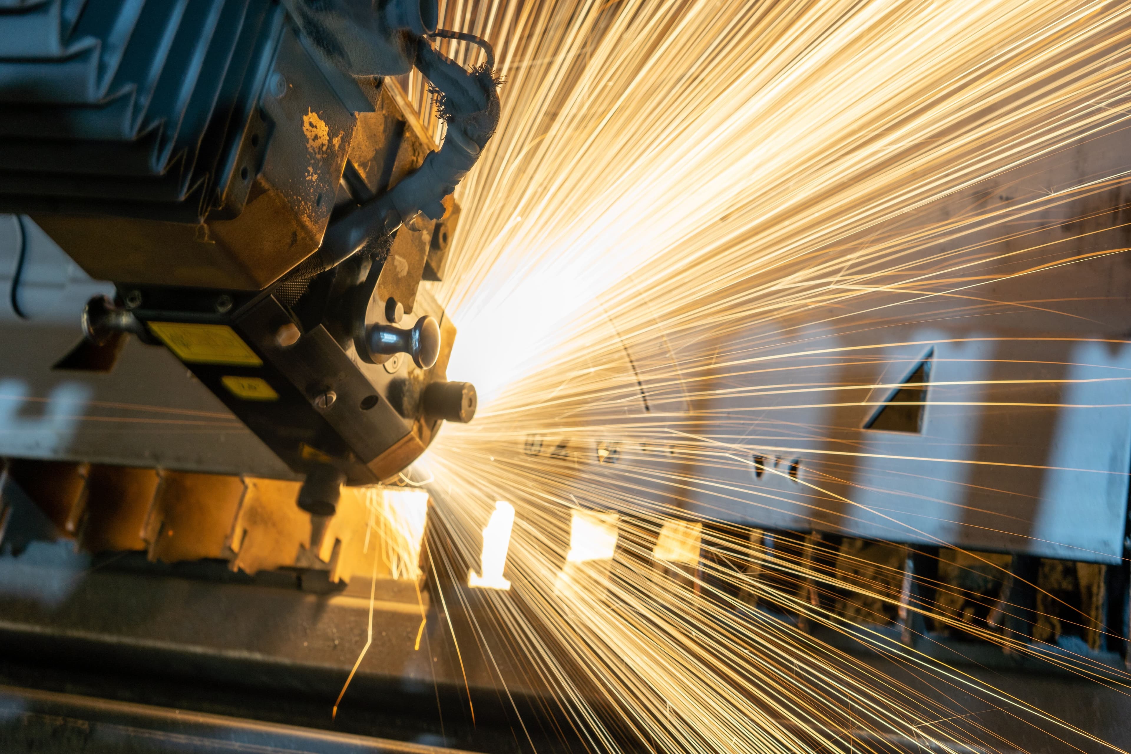 Industrial machine generating sparks during metal processing.